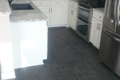 Small transitional u-shaped porcelain tile kitchen pantry photo in Baltimore with a drop-in sink, white cabinets, multicolored backsplash, stainless steel appliances, no island, raised-panel cabinets, granite countertops and glass tile backsplash