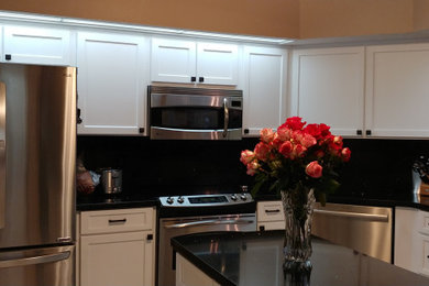 Mid-sized minimalist u-shaped eat-in kitchen photo in Tampa with shaker cabinets and white cabinets