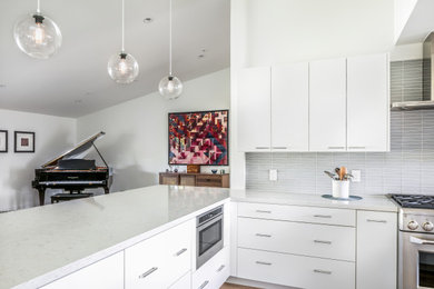 Eat-in kitchen - contemporary l-shaped eat-in kitchen idea in Phoenix with flat-panel cabinets, white cabinets, marble countertops, gray backsplash, ceramic backsplash, stainless steel appliances, white countertops and no island