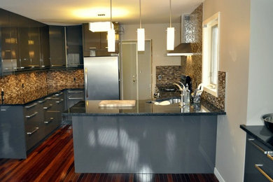 This is an example of a medium sized modern u-shaped kitchen/diner in Calgary with flat-panel cabinets, granite worktops, mosaic tiled splashback, stainless steel appliances, grey cabinets, multi-coloured splashback, a breakfast bar, a submerged sink, dark hardwood flooring and brown floors.
