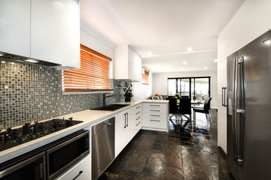 На фото: большая кухня-гостиная в стиле модернизм с серым фартуком и полом из сланца без острова