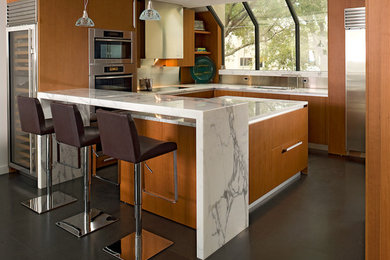 Exempel på ett avskilt, mellanstort modernt u-kök, med en undermonterad diskho, släta luckor, skåp i mellenmörkt trä, marmorbänkskiva, vitt stänkskydd, stänkskydd i sten, rostfria vitvaror, kalkstensgolv och en köksö