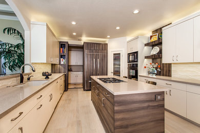 This is an example of a medium sized modern galley kitchen/diner in Sacramento with a submerged sink, flat-panel cabinets, white cabinets, beige splashback, ceramic splashback, black appliances, ceramic flooring and multiple islands.