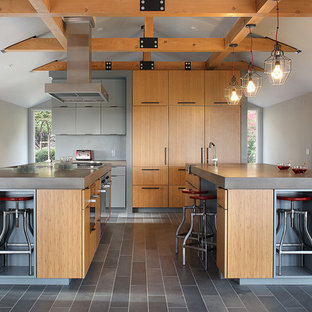 Ispirazione per una grande cucina minimal con lavello integrato, ante lisce, ante in legno chiaro, top in cemento, elettrodomestici da incasso, pavimento in cementine, 2 o più isole, pavimento grigio e top grigio
