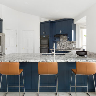 Design ideas for a mid-sized modern u-shaped kitchen pantry in Salt Lake City with an undermount sink, flat-panel cabinets, blue cabinets, granite benchtops, multi-coloured splashback, granite splashback, stainless steel appliances, laminate floors, a peninsula, grey floor, multi-coloured benchtop and vaulted.