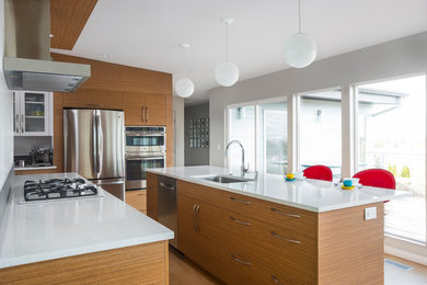 Inspiration for a large 1960s l-shaped light wood floor and beige floor enclosed kitchen remodel in Boise with flat-panel cabinets, light wood cabinets, quartz countertops, an island, an undermount sink and stainless steel appliances