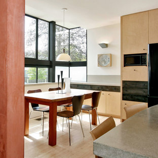 Esempio di una cucina abitabile minimalista con ante lisce, ante in legno chiaro e top in cemento