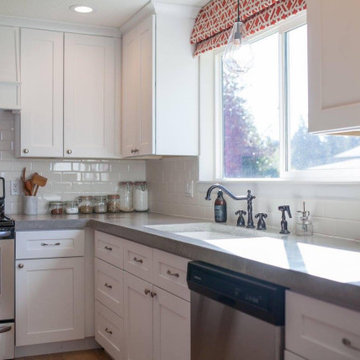 Modern kitchen, white cabinets, white backsplash, and gray concrete counters