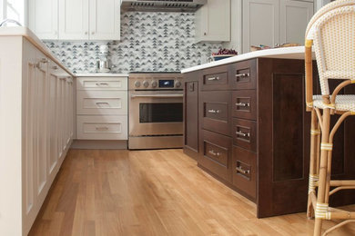 Example of a large minimalist l-shaped medium tone wood floor and brown floor eat-in kitchen design in Boston with a single-bowl sink, shaker cabinets, quartz countertops, gray backsplash, stone tile backsplash, paneled appliances, an island and white cabinets