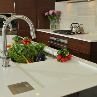 Photo of a mid-sized contemporary l-shaped open plan kitchen in Chicago with an integrated sink, flat-panel cabinets, dark wood cabinets, quartz benchtops, beige splashback, panelled appliances, with island, light hardwood floors and stone tile splashback.