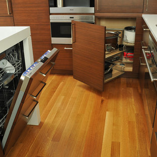 Mid-sized contemporary l-shaped open plan kitchen in Chicago with an integrated sink, flat-panel cabinets, dark wood cabinets, quartz benchtops, beige splashback, panelled appliances, with island, light hardwood floors and stone tile splashback.