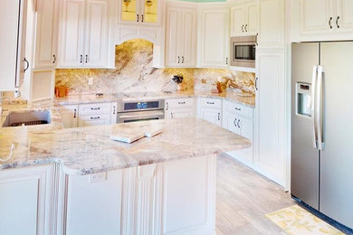 Enclosed kitchen - large modern u-shaped light wood floor and beige floor enclosed kitchen idea in Atlanta with granite countertops, multicolored backsplash, marble backsplash, stainless steel appliances and a peninsula