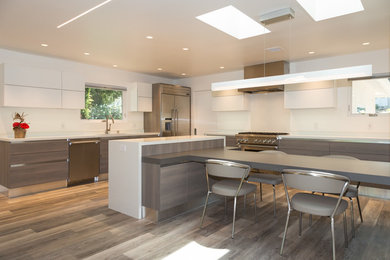 Example of a large minimalist l-shaped eat-in kitchen design in Miami with quartz countertops and two islands