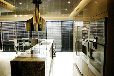 Esempio di una cucina moderna di medie dimensioni con lavello sottopiano, ante lisce, ante beige, top in granito, elettrodomestici in acciaio inossidabile, pavimento beige, pavimento in cemento e top beige