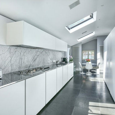 Eat-in kitchen - modern gray floor eat-in kitchen idea in London with an integrated sink, flat-panel cabinets, white cabinets, stainless steel countertops, white backsplash, marble backsplash and no island