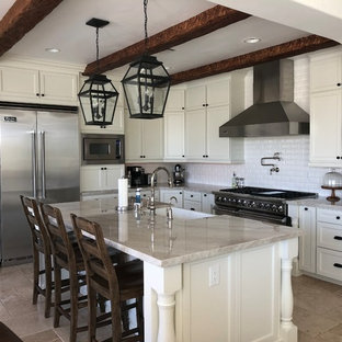 Offene, Große Mediterrane Küche in L-Form mit Landhausspüle, Schrankfronten im Shaker-Stil, weißen Schränken, Quarzit-Arbeitsplatte, Küchenrückwand in Weiß, Rückwand aus Keramikfliesen, Küchengeräten aus Edelstahl, Marmorboden, Kücheninsel, beigem Boden und bunter Arbeitsplatte in Las Vegas