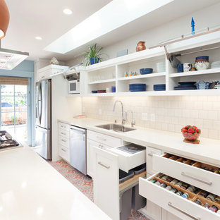 This is an example of a traditional galley kitchen in San Francisco with an undermount sink, shaker cabinets, white cabinets, white splashback, stainless steel appliances, with island, subway tile splashback, ceramic floors, multi-coloured floor, white benchtop and quartzite benchtops.