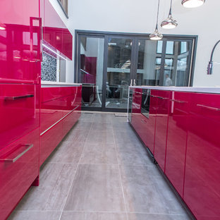 Photo of an expansive contemporary single-wall eat-in kitchen in New York with an undermount sink, flat-panel cabinets, quartz benchtops, black splashback, glass tile splashback, panelled appliances and porcelain floors.