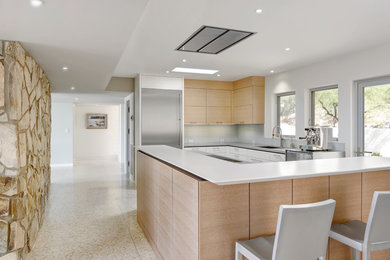 Medium sized modern l-shaped open plan kitchen in Phoenix with a submerged sink, flat-panel cabinets, light wood cabinets, engineered stone countertops, white splashback, glass tiled splashback, stainless steel appliances and an island.