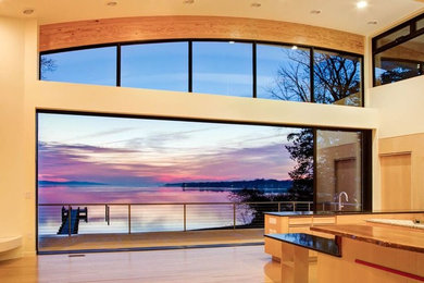 Inspiration for a large modern l-shaped open plan kitchen in Baltimore with a submerged sink, flat-panel cabinets, light wood cabinets, granite worktops, stainless steel appliances, bamboo flooring, multiple islands and brown floors.