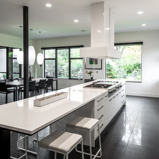 Photo of an expansive contemporary galley open plan kitchen in Minneapolis with with island, a single-bowl sink, flat-panel cabinets, white cabinets, quartz benchtops, white splashback, white appliances and porcelain floors.