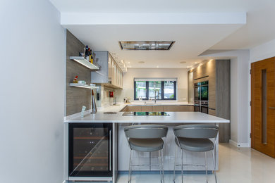 This is an example of a medium sized modern u-shaped kitchen in Sussex with a breakfast bar.