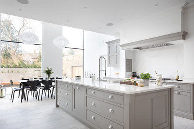 Photo of a large modern u-shaped open plan kitchen in London with shaker cabinets, grey cabinets, quartz worktops, white splashback, marble splashback, stainless steel appliances, marble flooring, an island, beige floors and white worktops.
