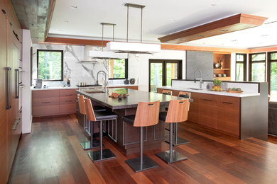 This is an example of a contemporary u-shaped kitchen/diner in Toronto with a submerged sink, flat-panel cabinets, dark wood cabinets, white splashback, stone slab splashback, dark hardwood flooring, multiple islands and granite worktops.