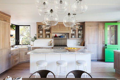 Exempel på ett klassiskt kök, med skåp i shakerstil, marmorbänkskiva, ljust trägolv och en köksö