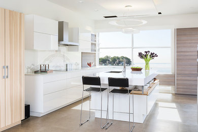 Example of a large trendy porcelain tile kitchen design in New York with an undermount sink, flat-panel cabinets, white cabinets, quartz countertops, white backsplash, stone slab backsplash and an island