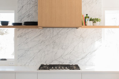 Idéer för ett litet modernt vit l-kök, med en undermonterad diskho, släta luckor, vita skåp, bänkskiva i kvarts, vitt stänkskydd, stänkskydd i marmor, rostfria vitvaror, mellanmörkt trägolv och brunt golv