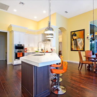 Contemporary eat-in kitchen designs - Trendy eat-in kitchen photo in Miami with stainless steel appliances, raised-panel cabinets and white cabinets