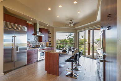 Example of a minimalist u-shaped porcelain tile eat-in kitchen design in Phoenix with an undermount sink, flat-panel cabinets, granite countertops, multicolored backsplash, glass tile backsplash, stainless steel appliances, an island and medium tone wood cabinets
