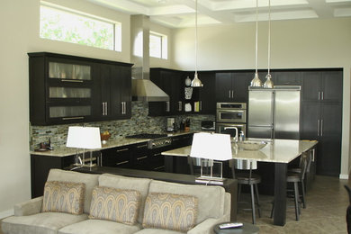 Minimalist l-shaped open concept kitchen photo in Jacksonville with a drop-in sink, shaker cabinets, dark wood cabinets, stainless steel appliances and an island