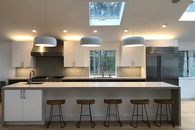 Example of a large minimalist light wood floor and beige floor eat-in kitchen design in New York with an island, an undermount sink, flat-panel cabinets, white cabinets, quartzite countertops, gray backsplash, stainless steel appliances and gray countertops