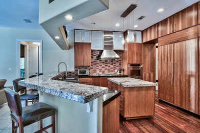 Eat-in kitchen - mid-sized contemporary dark wood floor eat-in kitchen idea in Miami with flat-panel cabinets, granite countertops, glass tile backsplash and an island