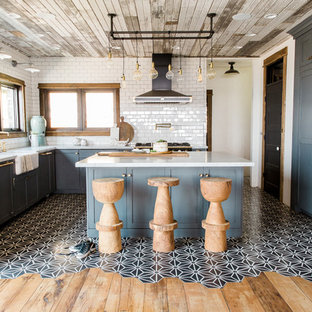 Inspiration for an industrial u-shaped kitchen in Salt Lake City with shaker cabinets, blue cabinets, white splashback, subway tile splashback, panelled appliances, cement tiles, with island, multi-coloured floor and white benchtop.
