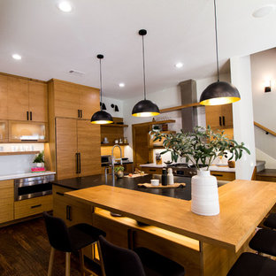 Large scandinavian eat-in kitchen designs - Large danish dark wood floor and brown floor eat-in kitchen photo in Dallas with flat-panel cabinets, light wood cabinets, granite countertops, white backsplash, subway tile backsplash, stainless steel appliances, an island and black countertops