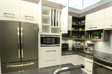 Mid-sized minimalist l-shaped kitchen photo in Toronto with an undermount sink, flat-panel cabinets, quartz countertops, stainless steel appliances, an island and gray countertops