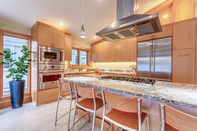 Immagine di una cucina moderna di medie dimensioni con lavello sottopiano, ante lisce, ante in legno chiaro, top in granito, paraspruzzi con piastrelle di metallo, elettrodomestici in acciaio inossidabile e pavimento con piastrelle in ceramica