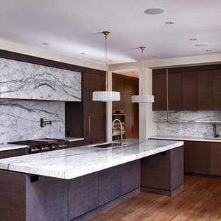 Idee per un'ampia cucina minimalista con lavello sottopiano, ante lisce, ante in legno bruno, top in marmo, paraspruzzi bianco, paraspruzzi in lastra di pietra, elettrodomestici in acciaio inossidabile, pavimento in legno massello medio e isola
