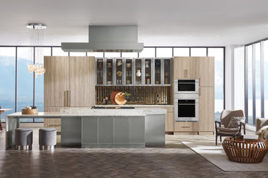 Eat-in kitchen - huge contemporary single-wall eat-in kitchen idea in Cedar Rapids with flat-panel cabinets, light wood cabinets, metallic backsplash, stainless steel appliances and an island