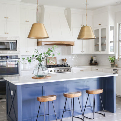 Example of a mid-sized transitional l-shaped gray floor and porcelain tile open concept kitchen design in Other with an undermount sink, shaker cabinets, white cabinets, white backsplash, stainless steel appliances, an island, white countertops, quartzite countertops and ceramic backsplash