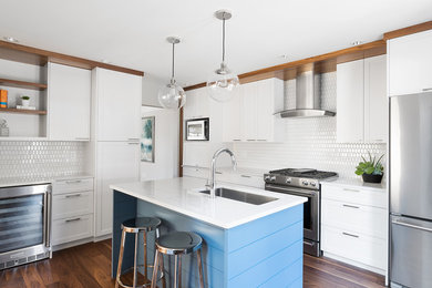 Inspiration for a transitional l-shaped dark wood floor kitchen remodel in Other with an undermount sink, shaker cabinets, white cabinets, white backsplash, stainless steel appliances and an island