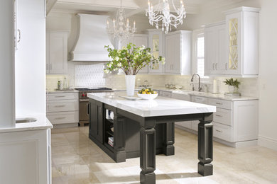 Example of a large classic u-shaped eat-in kitchen design in Philadelphia with a farmhouse sink, recessed-panel cabinets, white cabinets, white backsplash, stainless steel appliances, an island and white countertops