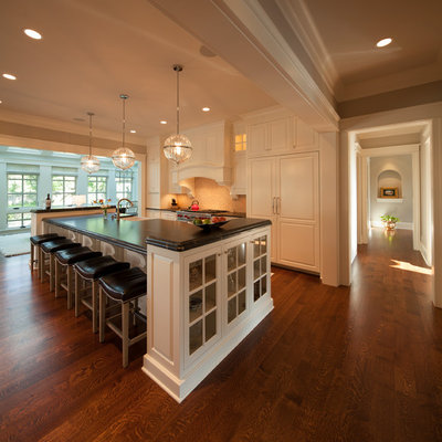 Inspiration for a transitional galley kitchen remodel in Minneapolis with a farmhouse sink, raised-panel cabinets, white cabinets and paneled appliances