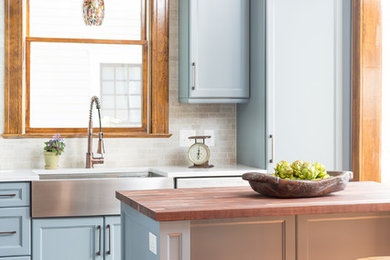 Exempel på ett mellanstort klassiskt kök, med en rustik diskho, luckor med infälld panel, blå skåp, träbänkskiva, stänkskydd i stenkakel, mellanmörkt trägolv, en köksö och flerfärgad stänkskydd