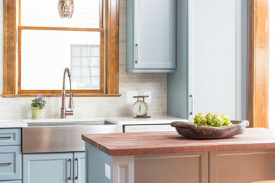 Medium sized traditional kitchen in Atlanta with a belfast sink, recessed-panel cabinets, blue cabinets, wood worktops, stone tiled splashback, medium hardwood flooring, an island and multi-coloured splashback.