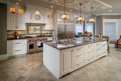 Example of a large ornate single-wall porcelain tile and gray floor open concept kitchen design in Other with an undermount sink, raised-panel cabinets, white cabinets, quartzite countertops, green backsplash, porcelain backsplash, stainless steel appliances, an island and gray countertops