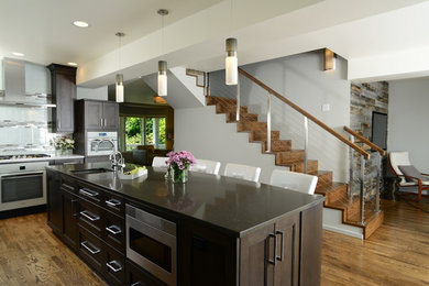 Foto på ett funkis kök och matrum, med en undermonterad diskho, släta luckor, vita skåp, bänkskiva i kvarts, stänkskydd i glaskakel, vita vitvaror, mörkt trägolv och en köksö
